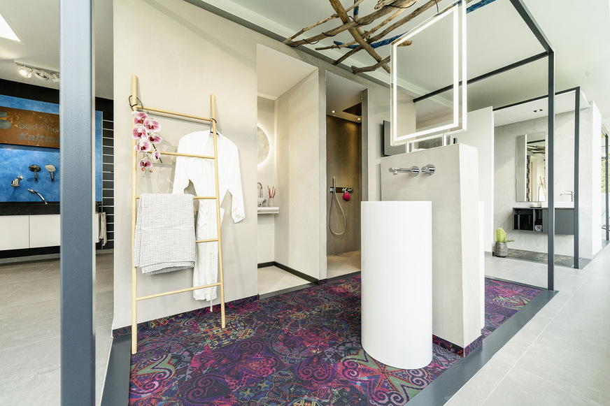 Cube 2 präsentiert einen Badentwurf mit abgemauertem Duschbereich, einem separaten WC-Bereich und einer besonderen Doppel-Waschplatzlösung: Die Becken sind hier gegenüber angeordnet und die Installation nicht an eine Wand gebunden. Dadurch ist auch eine offene Platzierung, z. B. im Anschluss an ein Schlafzimmer, möglich. Der auffällige Teppich besteht aus recycelten PET-Flaschen.