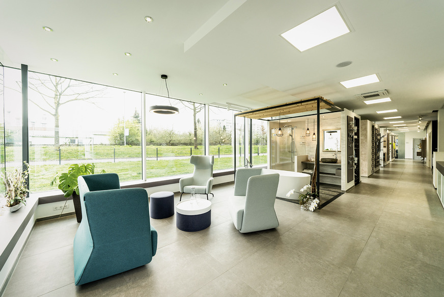 Im Eingangsbereich der Ausstellung wurde bewusst ein helles, freundliches und luftiges Lounge-Konzept statt eines weiteren Cubes realisiert. Speziell ausgesuchte Sitzmöbel schaffen dort eine „Wohnzimmer-Wohlfühlatmosphäre“ für die Besucher.