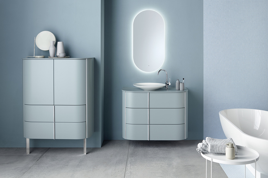 Diese Möbel machen das Badezimmer zum Salon: Ein Waschtisch wie eine Kommode, elegante Konsolen und Sideboards, große erleuchtete Vitrinenschränke und ­repräsentative Highboards sind die Highlights der neuen Badmöbelkollektion Lavo 2.0 von burgbad. Für eine moderne Farbgebung im Bad sorgen in Matt gehaltene Trendfarben wie Eisblau, Graphit oder Basaltgrau und diverse Holzdekore. Sanft gerundete Möbelfronten harmonieren mit dem Oval von Mineralgusswaschtisch und Leuchtspiegel und geben dem Badezimmer einen wohnlichen Charakter.