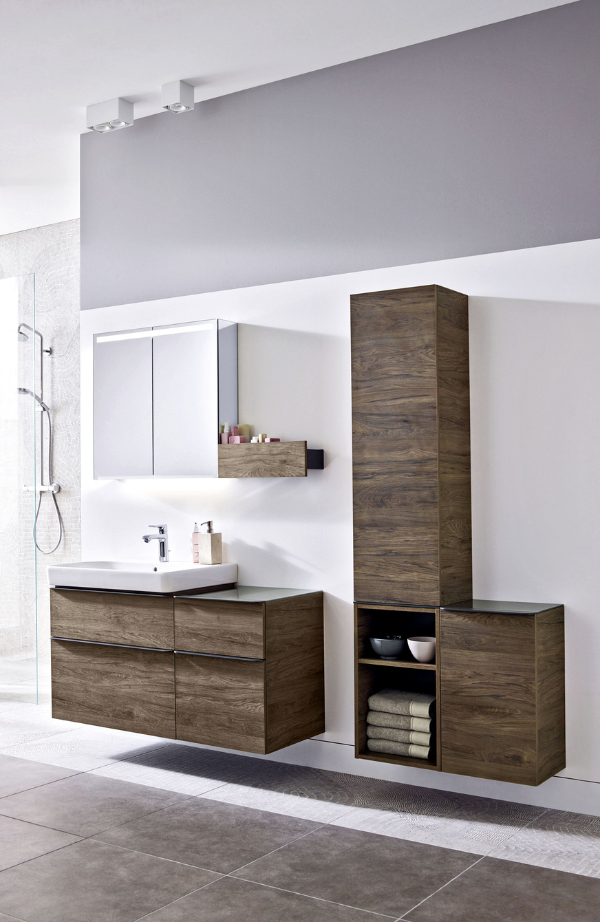 Warme Holztöne sorgen für ein wohnliches Ambiente. Der Kombinations-vielfalt sind mit offenen und geschlossenen Schrankelementen und Ablageflächen, Waschtischunter-schränken, Wandboards und Spiegelschränken keine Grenzen gesetzt, hier die Badserie Geberit Smyle.