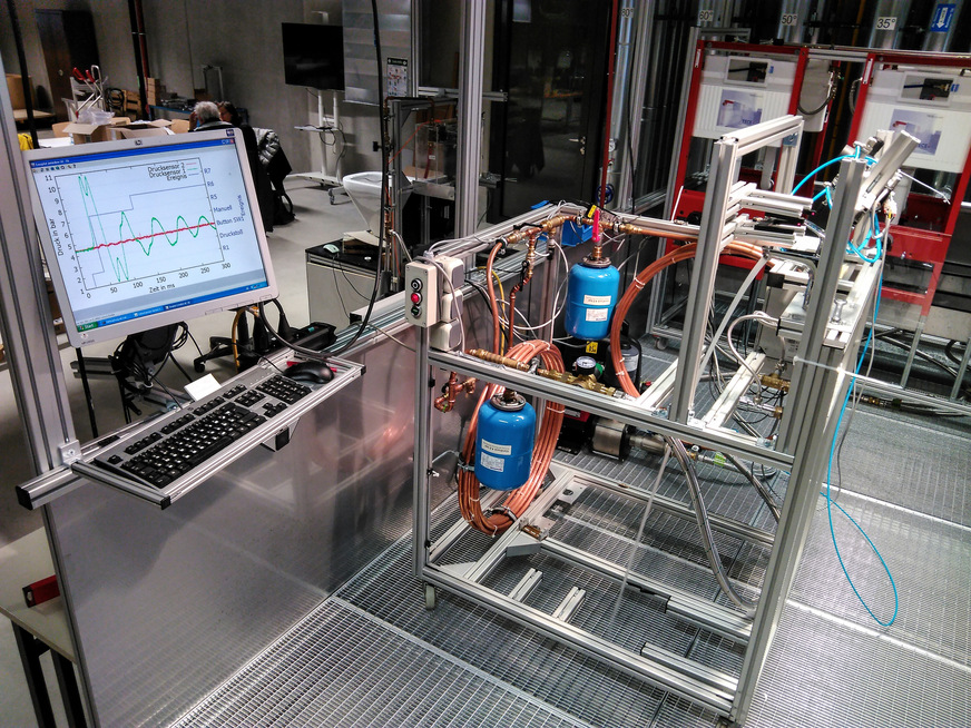 Der Prüfstand im Labor der Hochschule Esslingen wurde konzipiert und gebaut, um Druckschläge an Einhebelmischern zu messen. Er entspricht in der wesentlichen Ausstattung den einschlägigen Regelwerken, sodass damit DIN-konforme Produkttests durchgeführt werden können.