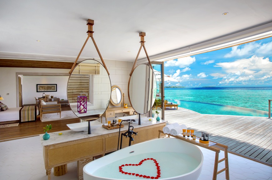 Frei stehende Badewanne in geschwungener Form in einer Water Pool Villa auf Milaidhoo Island Maldives mit Ausblick auf die endlose Weite des Indischen Ozeans. Das Luxusresort vereint auf der insgesamt 300 mal 180 Meter kleinen Insel entspannten Barfuß-Luxus mit maledivischem Charme.