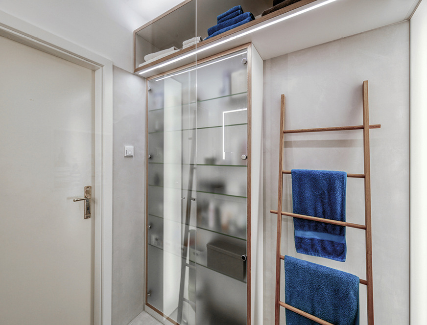Der Schrank hat zwar nur eine Tiefe von 20 cm, bietet aber dank seiner Größe viel Platz und eine gute Übersicht. Seine Mattglastüren lassen den Inhalt verschwimmen, die Tiefe aber noch erahnen.