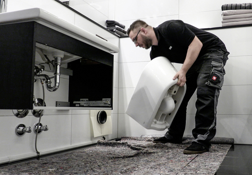 6 Die neue WC-Keramik, auf die das Dusch-WC als Nächstes aufgesetzt wird, wird montiert. Bei Toto ist die Stabdüse für die Intimreinigung aus hygienischen Gründen nicht in die Keramik integriert.