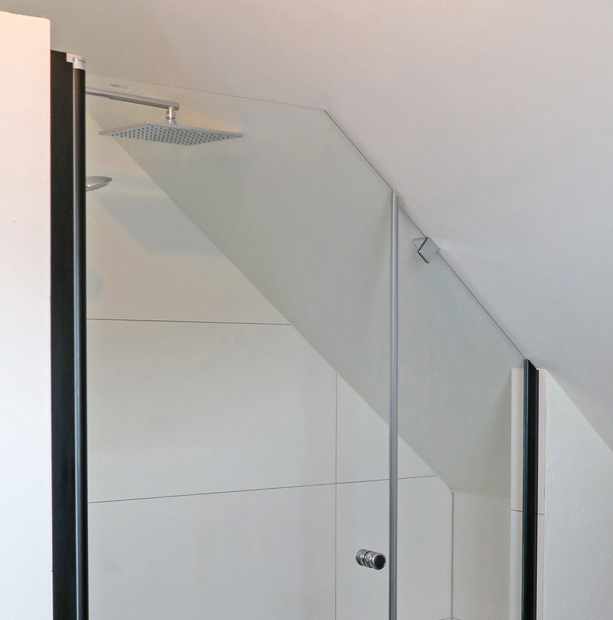 Die Schräge von Tür und Festteil soll in einer Linie verlaufen. Ein dezenter Glashalter fixiert das unbewegliche Element.