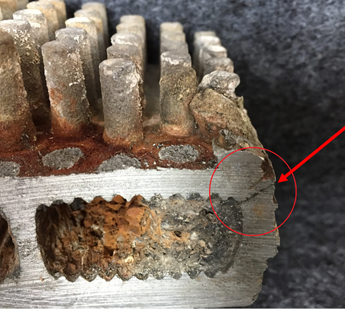 Bild 4: Defekter Wärmeerzeuger aus einer Aluminiumlegierung, der durch eingespülte Korrosionsprodukte und Kalkstein lokal überhitzt hat und gerissen ist.