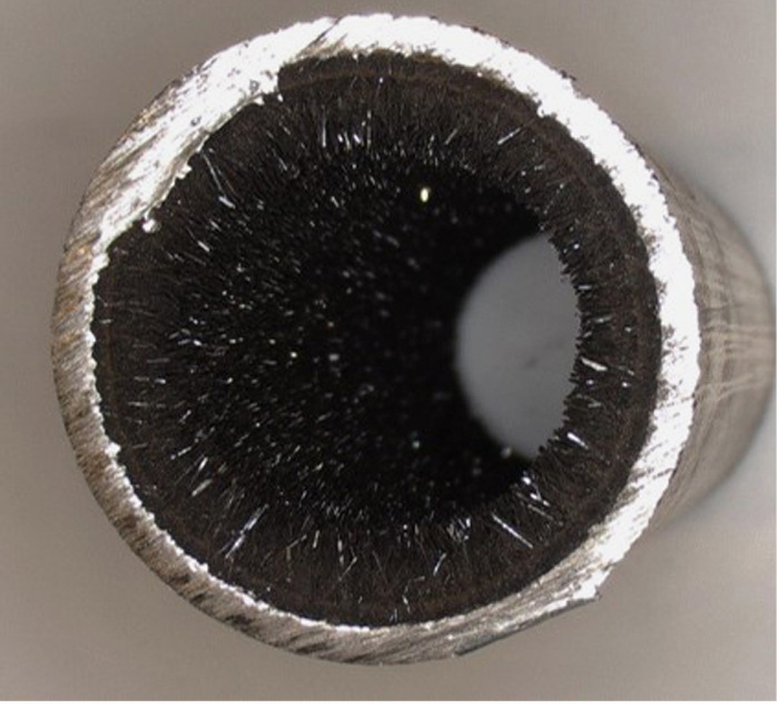 Bild 5: C-Stahlrohr mit einem kristallinen Belag aus Magnetit und Kalziumkarbonat (Aragonit), verursacht durch eine relativ hohe Resthärte in Verbindung mit übermäßigem Sauerstoffeintrag.