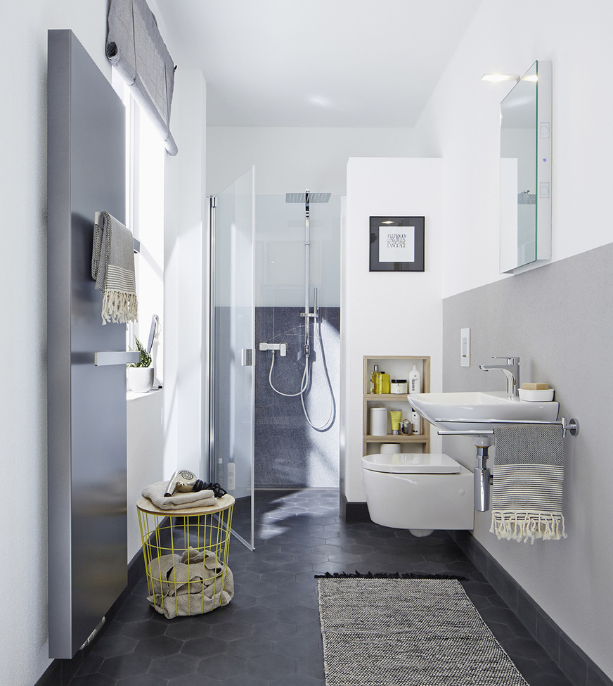 Die transparente Duschkabine Raya von Kermi wartet mit Gelenkbeschlägen mit glatten Profilen auf. Auch der Heiz­körper kann als Gestaltungselement in Grau genutzt werden.