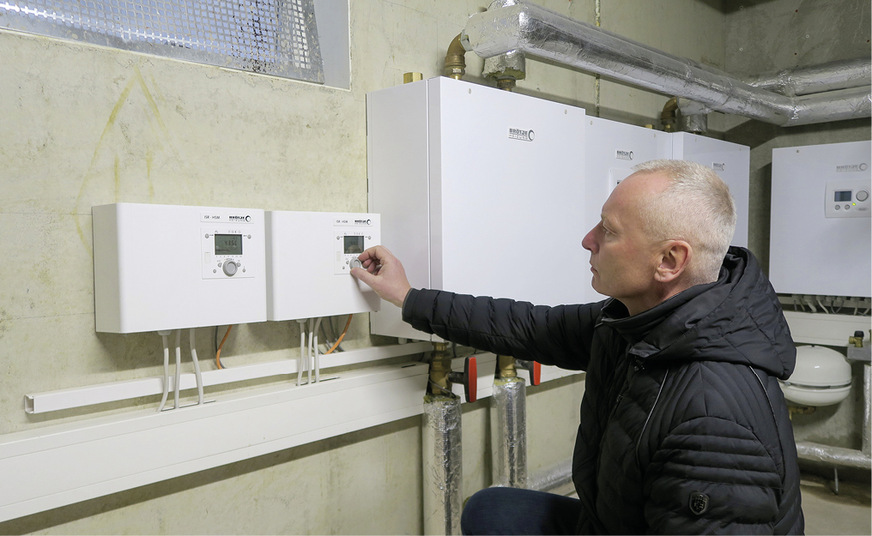Ingo Patzelt, Geschäftsführer der Ritze & Partner GmbH, inspiziert die Hydro- und Powerboxen der Wärmepumpen­kaskade im Technikraum.