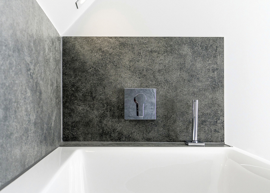 Neben dem Boden sind auch die Wände im Nassbereich und die Fensterbänke mit großformatigen Fliesen belegt.