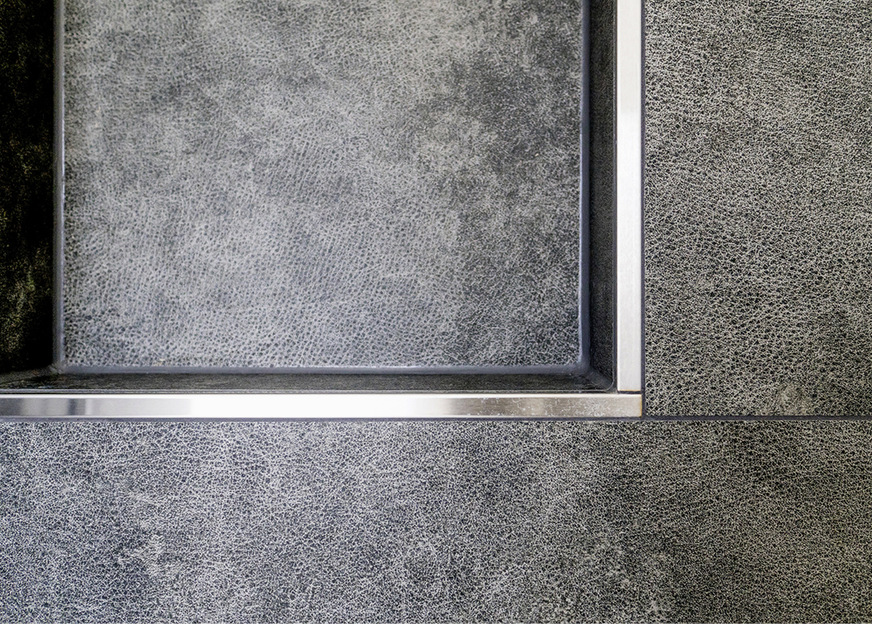 Präzise verarbeitete Edelstahlschienen an den Außenecken schaffen eine klare Trennung.