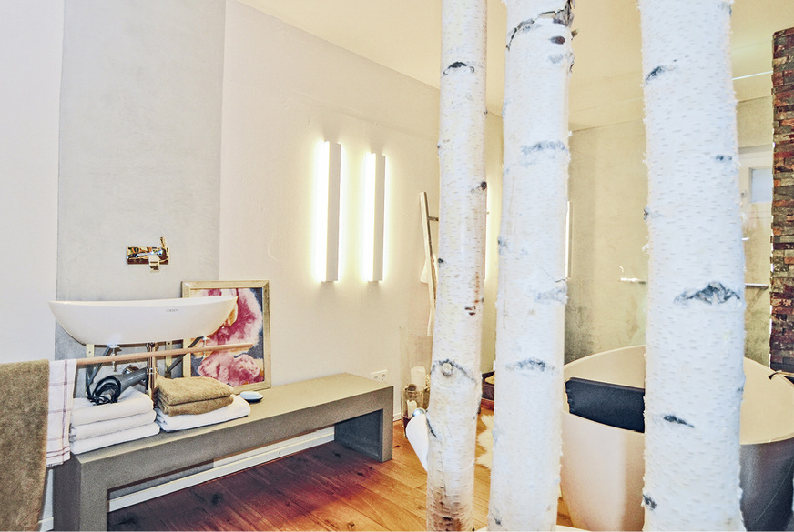 Die Birkenstämme erfüllen einen dekorativen Zweck, verstärken den Bezug zur Natur, spenden ausreichend Intimsphäre und sind ideal geeignet, um den einfachen, aber praktischen Papierrollenhalter anzubringen.