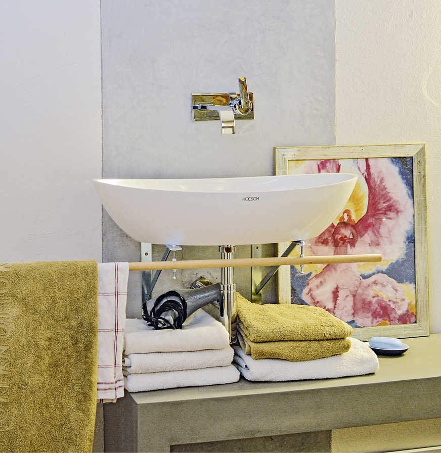 Die Schale sitzt nun auf zwei filigranen Stahlträgern, die daran angeschraubte asymmetrische Holzstange dient als saloppe Handtuchstange.