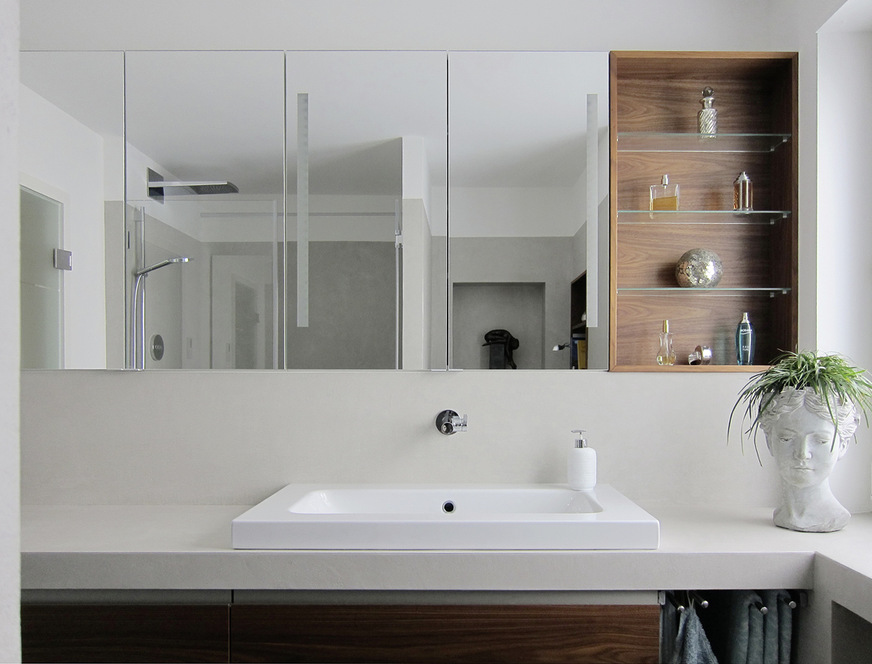 Die Fläche über der Vorwand wird für eine Spiegelschrank-Anlage auf Maß genutzt. Die Spiegelflächen lassen den Raum größer wirken. Für ...