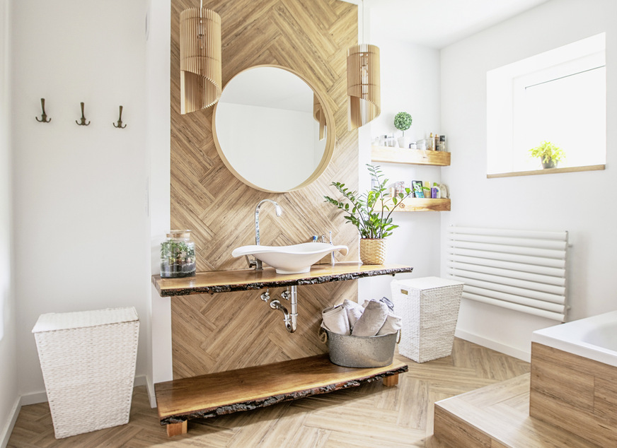 Bild 9: Kolonialstil mit Blockhaus-Feeling auf der Wand: Davor strahlen die weißen Bad­möbel und die feine Keramik Eleganz und Hygiene aus, ohne dass es klinisch ungemütlich wird.