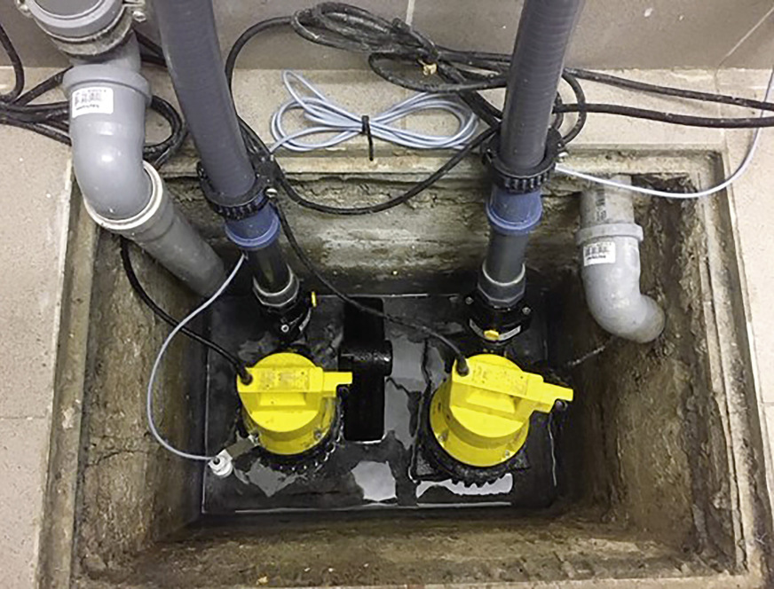 Schmutzwasserinstallation in einem Kellerschacht inkl. Rückschlagklappen und Niveaukontakt für den Hochwasseralarm.