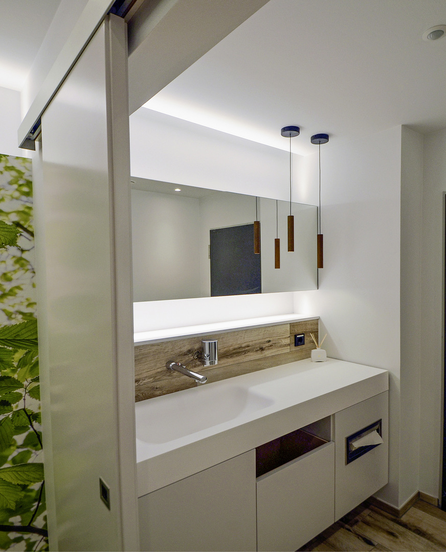 Die Waschplätze im vorderen Bereich der WC-Räume werden von einem wandbündig angepassten Waschtisch dominiert (Material: Corian).