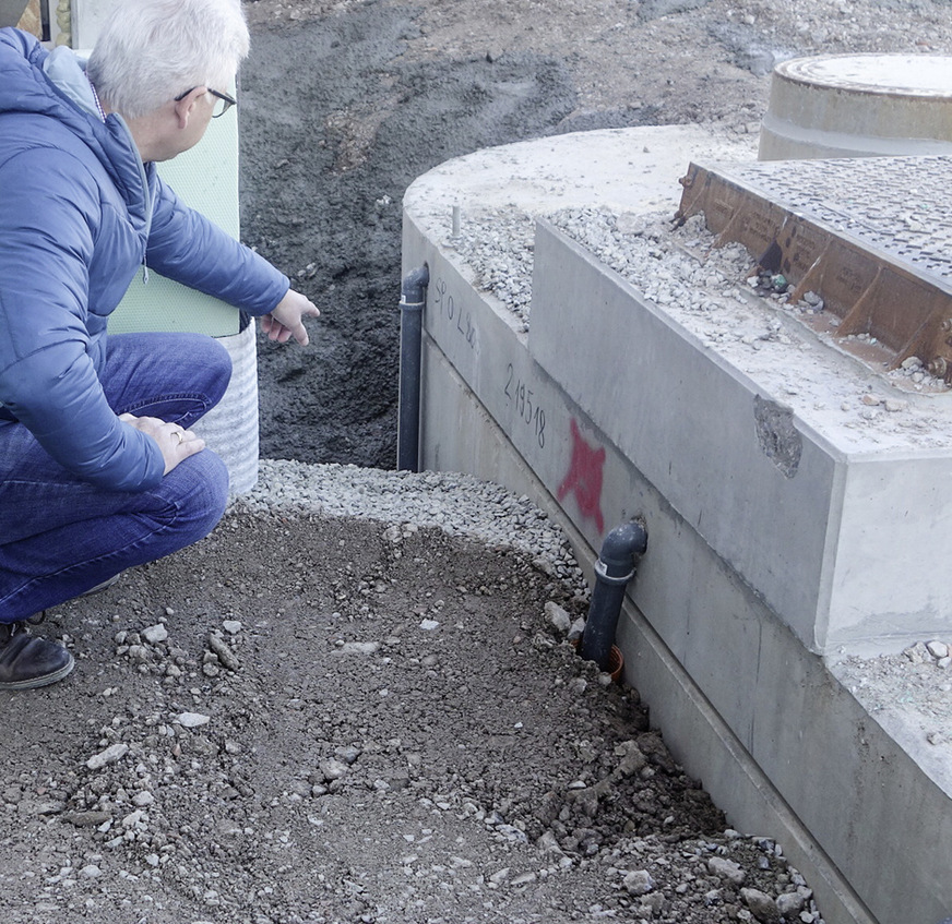 Ovalbehälter nach abgeschlossener Montage: Die drei runden Befüllöffnungen und der rechteckige Einstieg haben ab Werk in den Schachthälsen Kondenswasserabläufe DN 40 ins Erdreich – hier seitlich zu sehen.