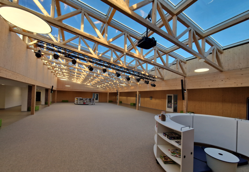 Neben acht Klassenräumen wurde auch eine große Halle im Neubau errichtet. Durch das System zur natürlichen Lüftung ist auch solch ein großer Raum bestens mit Frischluft versorgt.
