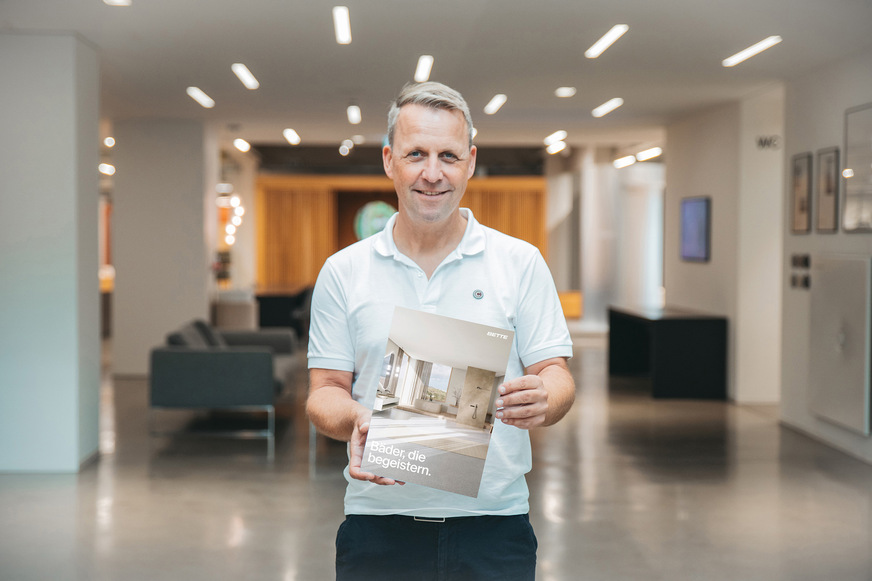 Sven Rensinghoff, Leiter Marketing & Produktmanagement bei Bette, präsentiert die neue Broschüre „Duschen“.