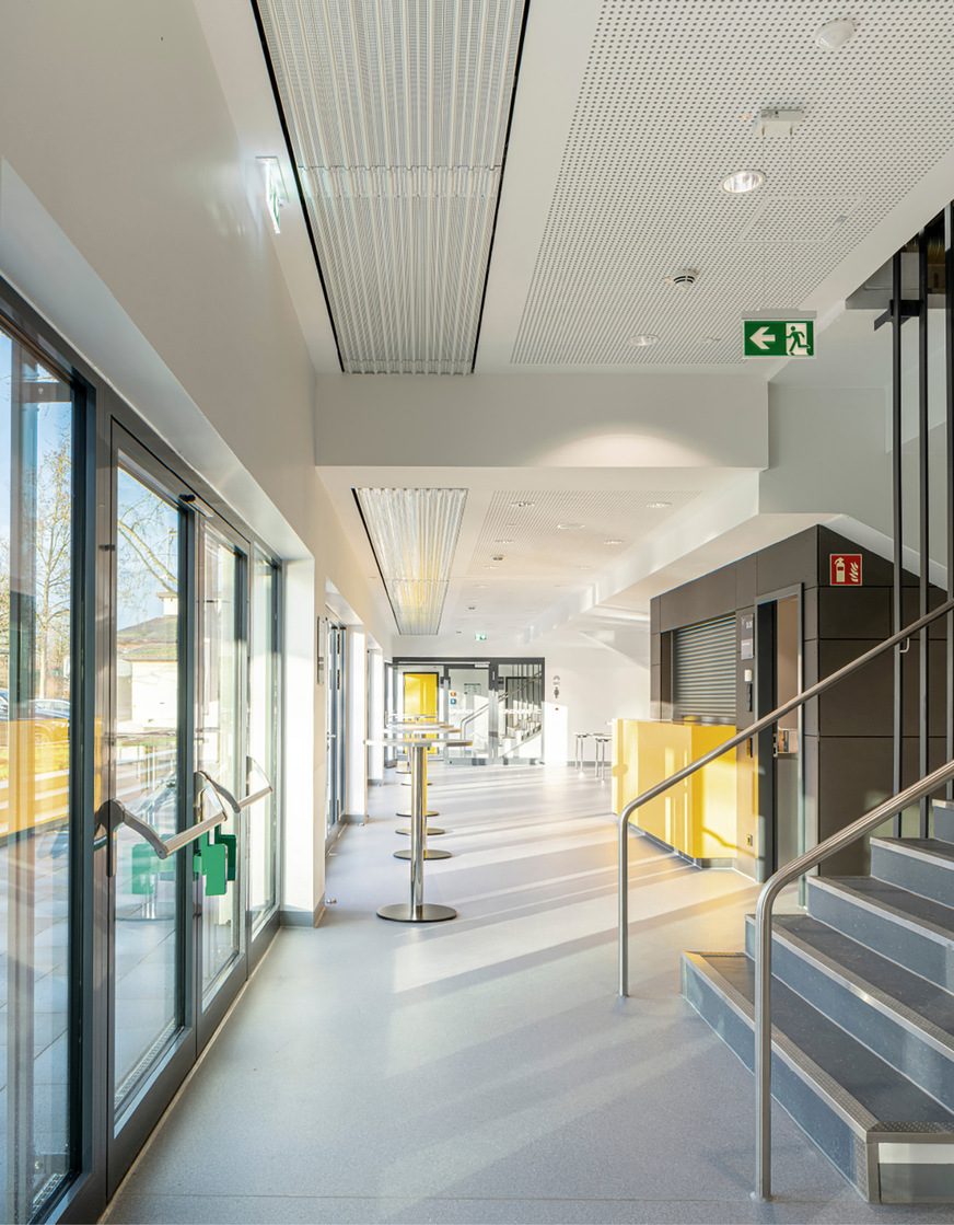 Das zum alten Teil des Sportkomplexes gehörende Foyer wurde während der Sanierungsarbeiten mit vier Bändern Deckenstrahlplatten Zehnder ZFP inklusive Revisionsblechen ausgestattet.