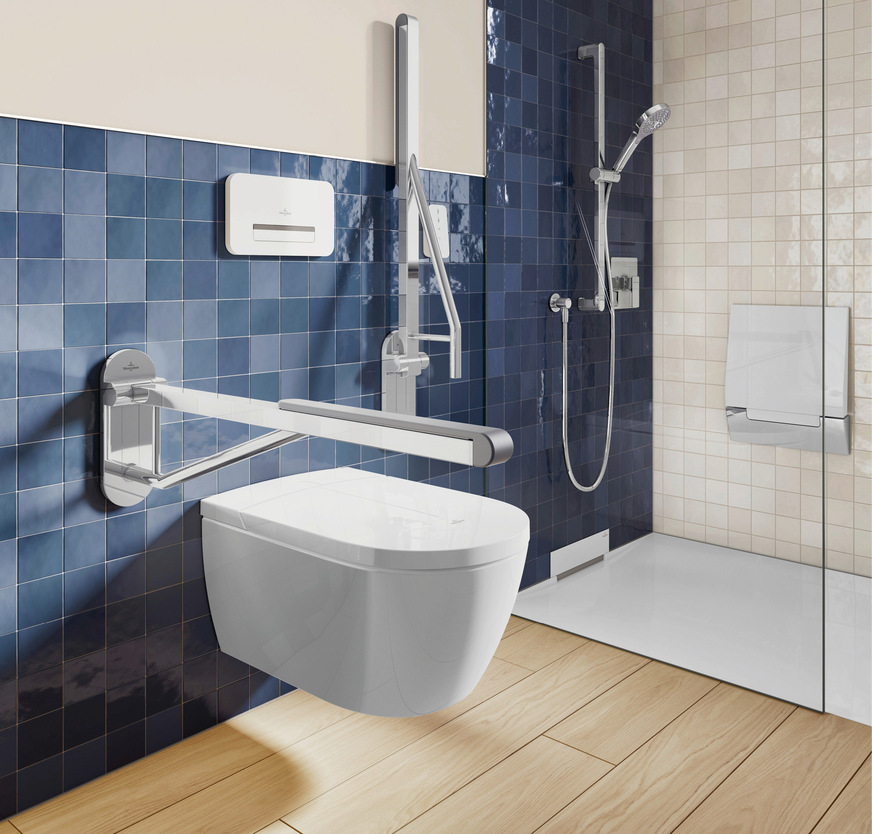 Deutlich besser: Das leise Farbspiel der blauen Fliesenwand und der Eindruck von Holz am Boden schaffen eine Balance von kalt und warm. WC und Griffe heben sich gut vor dunkleren Wandzonen ab.