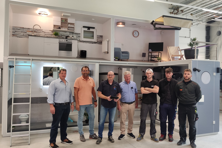 Freuen sich über die neue Werkstatt und das smarte Musterhaus (im Hintergrund): Richard Thielen (Geschäftsführer der Kreishandwerkerschaft Kleve), Klaus van Straelen (Vorstandsmitglied), Ralf van der Cruysen (Ausbildungs- und Werkstattleiter), Obermeister Michael Janßen sowie die Auszubildenden Astrit Jakupi, Philip Alefsen und Mark Mlynski (von links).