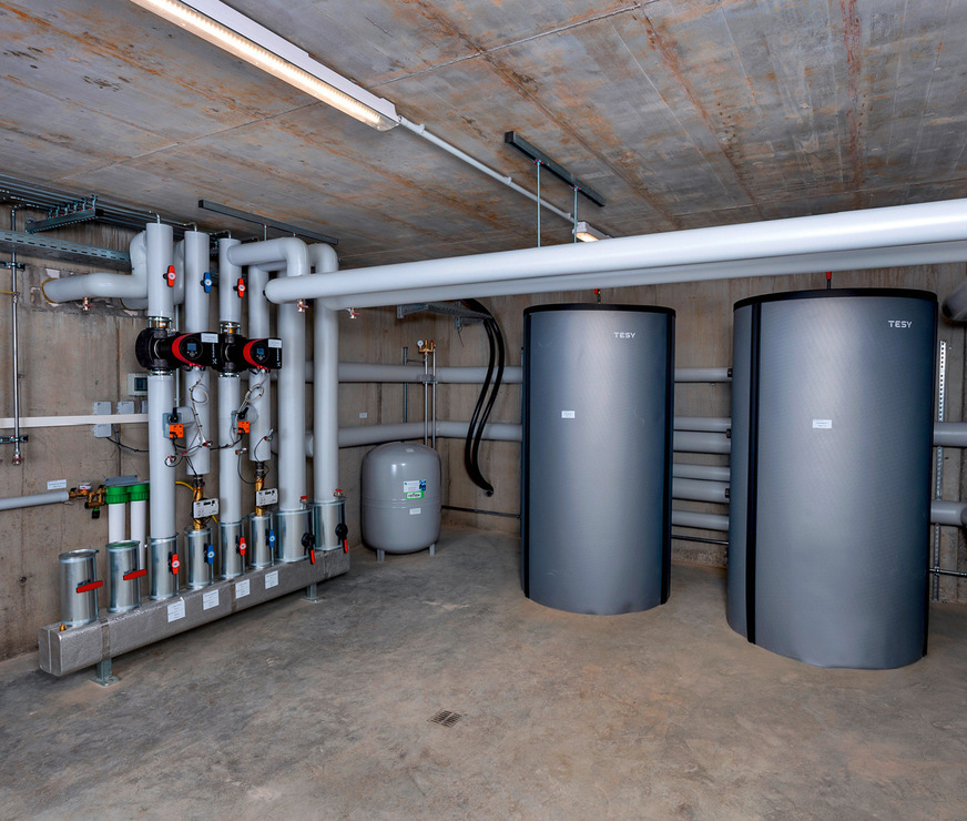 In den beiden Tiefgaragen befinden sich zwei Technikräume. Hier wird das Warmwasser von den Wärmepumpen in zwei Pufferspeicher geleitet und über Verteilerstationen in die Steigstränge befördert.