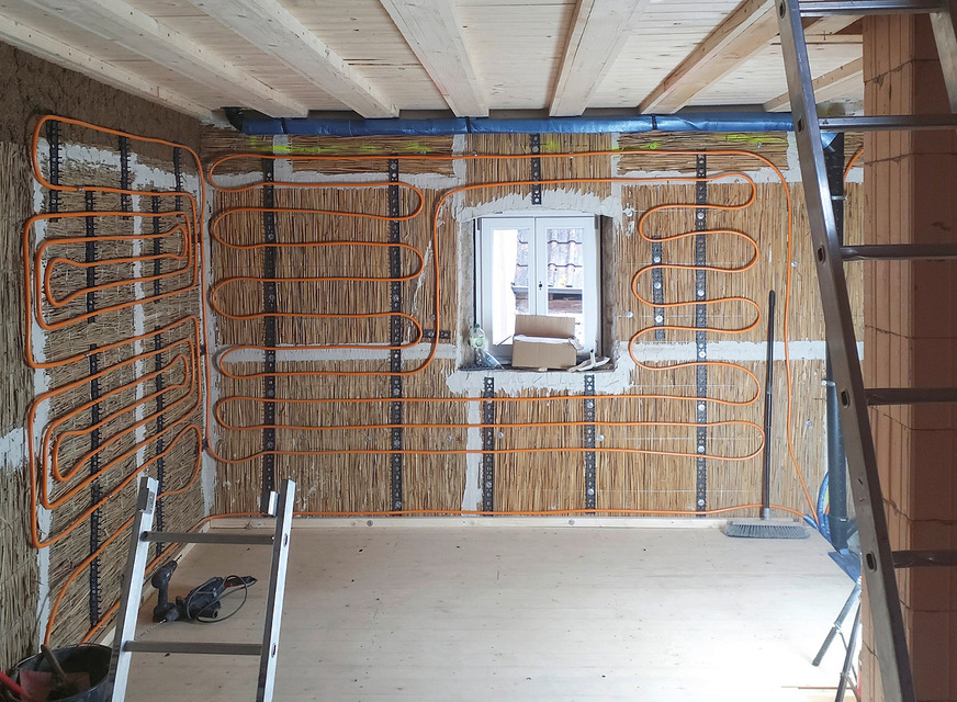 Wandheizung auf der Innendämmung eines landwirtschaftlichen Gebäudes, das für Wohnzwecke umgebaut wurde.