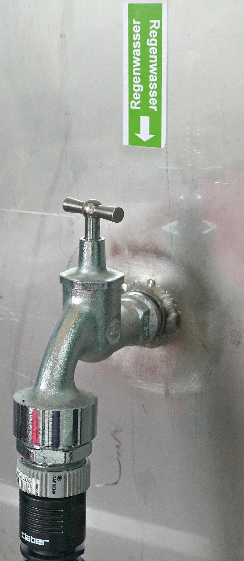 Kennzeichnung einer Entnahmestelle nach Vorgaben der DIN EN 16941-1, um Verwechslungen mit Trinkwasser durch die Nutzer zu verhindern. Sie befindet sich an einem großen Waschbecken für die Reinigung von Bauteilen in der Produktionshalle.