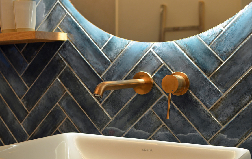 Blau und Gold wirken elegant, der runde Spiegel mit der umlaufenden Beleuchtung trägt seinen Teil dazu bei.