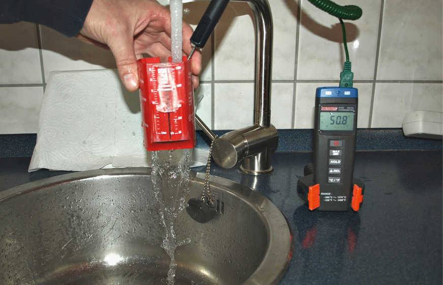 Der Durchfluss-Messbecher zeigt rund 7 l/min an. Die Temperatur liegt bei 50,8 °C.