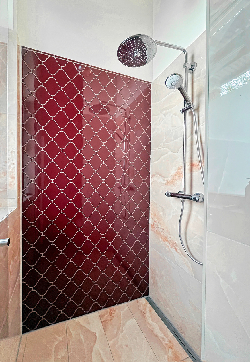 Gute Kombination: Fliesen in Ochsenblutrot an der Wand mit einem Feinsteinzeug, das den Naturstein Onyx zum Vorbild hat, in der Farbstufe Pink.