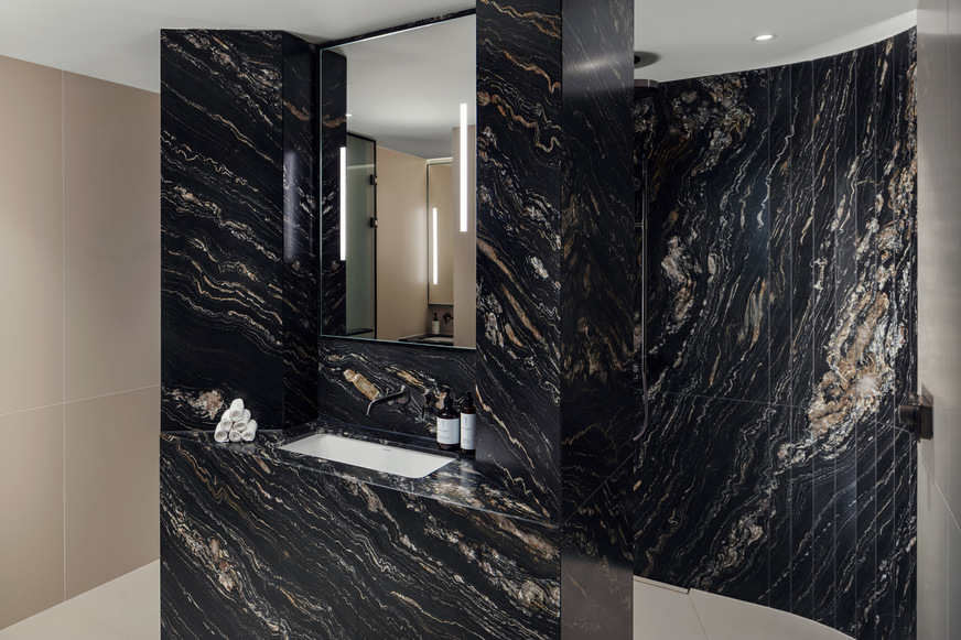 Im Spa-Bereich des Koenigshof sorgen klare Formen und edle Materialien für eine entspannte Atmosphäre. Das integrierte Vero Air-Waschbecken von Duravit fügt sich nahtlos in die skulpturale Natursteinverkleidung ein – ein Zusammenspiel aus Design, Funktion und Sinnlichkeit.