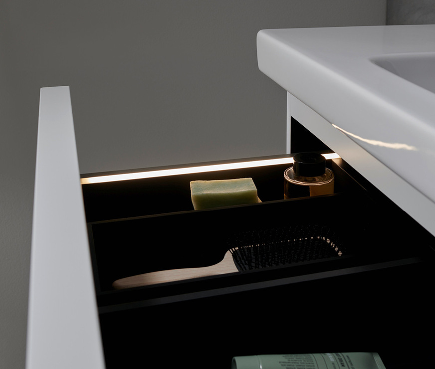 Integrierte Lichtstreifen in den Unterschrank-Schubladen schaffen Übersicht.