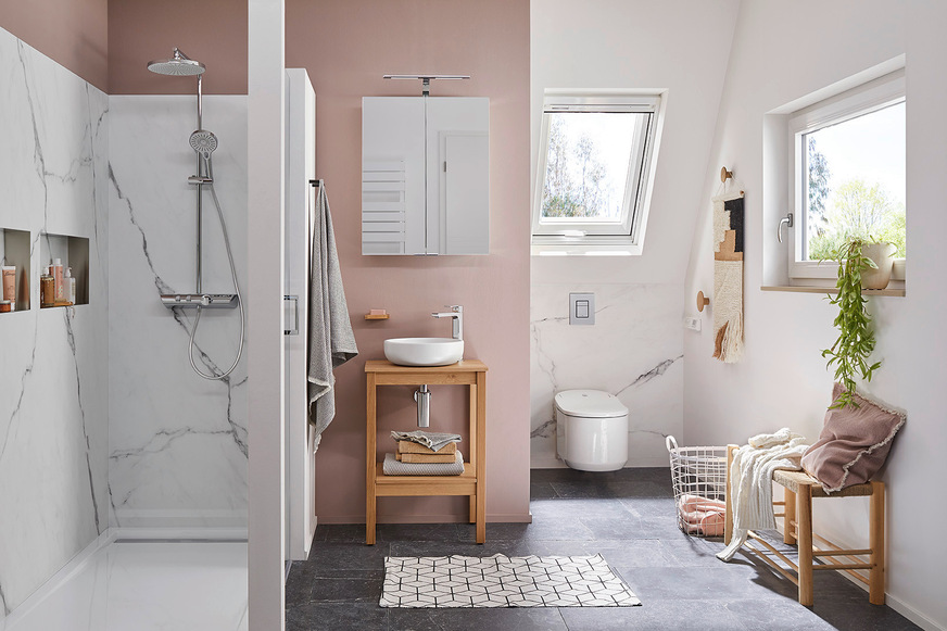 Die RenoDeco Platten Seidenmatt, Marmor, Carrara-Weiß kreieren in Kombination mit gedeckten Rosé-Tönen und stilvollen Holzakzenten einen edlen und gemütlichen Look – und das ohne eine einzige Fliese an der Wand.