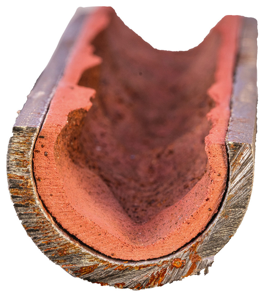 Innen beschichteter Rohrabschnitt einer Trinkwasserleitung mit stark unregelmäßiger, kraterartiger Oberflächenstruktur.