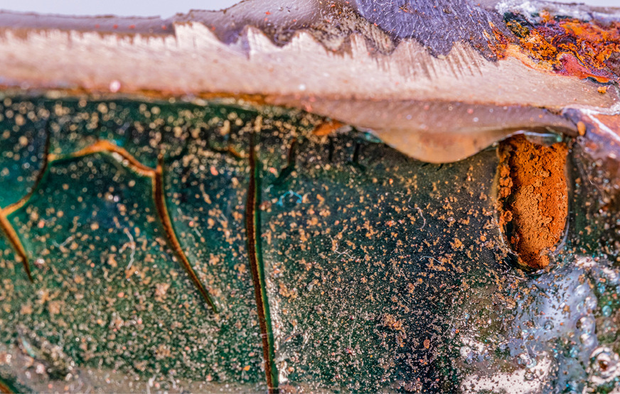 Innen beschichtete Trinkwasser­leitung mit fortgeschrittener Rissbildung, Schichtablösung und freiliegendem Grundmaterial infolge Unterwanderung und Korrosion.