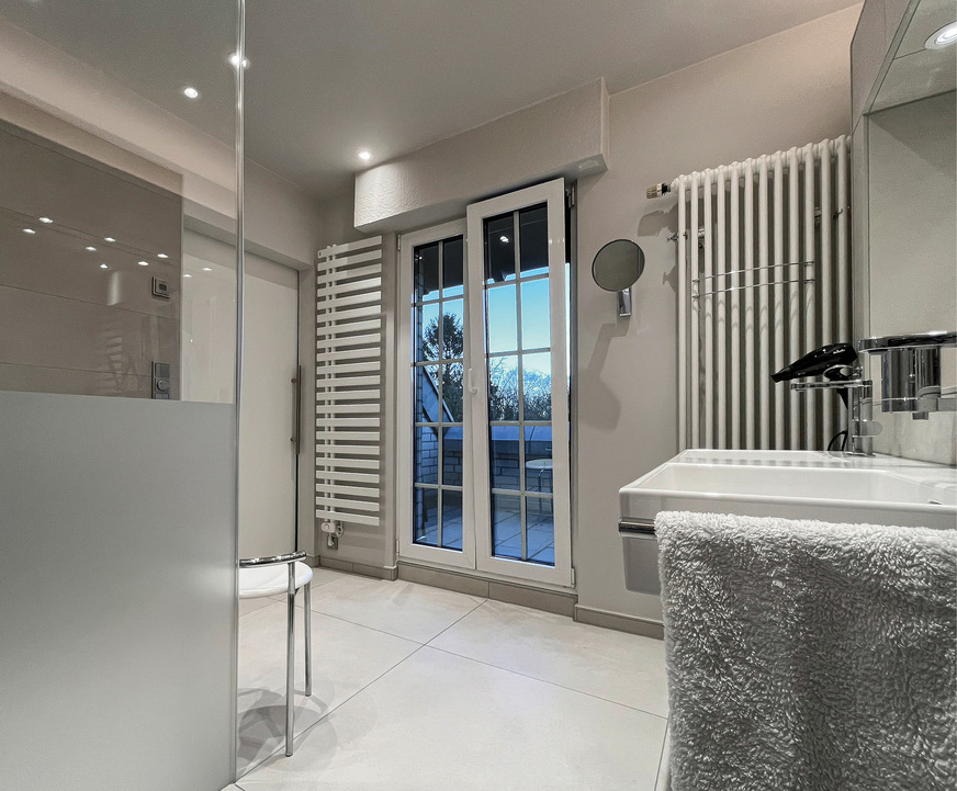 Das großzügige Badezimmer gewährt einen Blick in den Garten.