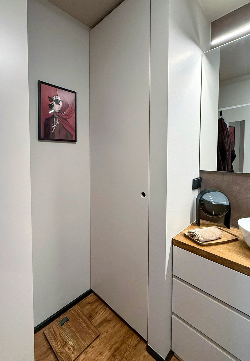 Der deckenhohe Schrank bietet Stauraum bei flacher Tiefe.
