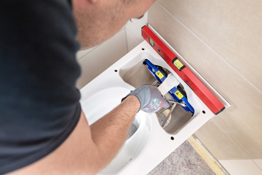 Die WC-Keramik wird komfortabel von oben an der Wand montiert. Verschraubung sowie Strom- und Wasseranschlüsse sind dabei gut zugänglich.