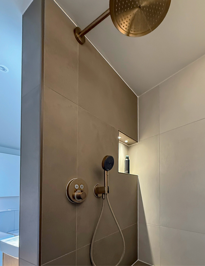 Am Fliesenplan orientieren sich die Position der seitlich offenen Shampoo-Nische und die Position der UP-Armaturen im Duschbereich inklusive der Regendusche.