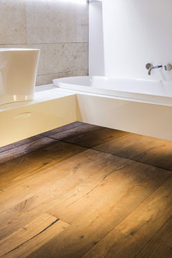 Da Holz ein eher warmes Material ist, bietet es sich auch als Fußbodenbelag im Bad an. Besonders dann, wenn das Bad direkt an ein Schlafzimmer mit Holzfußboden angrenzt.  - © Wahl GmbH