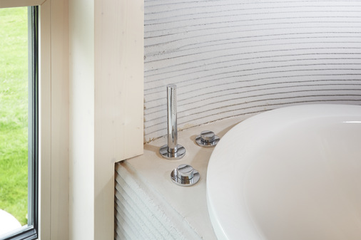 Die Materialien und Ausstattungen der Bäder sind passend zu der besonderen Wandbeschaffenheit gewählt worden. „Ohne Ecken und Kanten“ fügen sich die Edition-400-Accessoires von Keuco getreu dem Motto ein, ebenso wie … …. die Keuco IXMO-Wannenarmatur mit runden Rosetten.