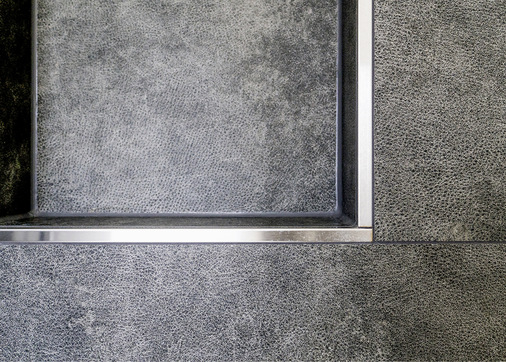 Präzise verarbeitete Edelstahlschienen an den Außenecken schaffen eine klare Trennung.