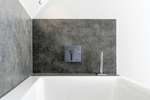 Neben dem Boden sind auch die Wände im Nassbereich und die Fensterbänke mit großformatigen Fliesen belegt.