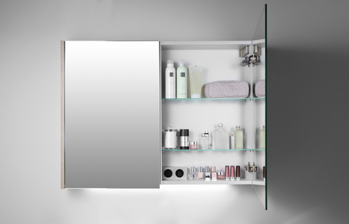 Der Spiegelschrank verstaut gekonnt alle Dinge und sorgt für Ordnung rund um den Waschplatz. Die Spiegelschränke sind in sieben Breiten von 60 bis 140 cm erhältlich. Die Glaseinlegeböden sind höhenverstellbar, so dass alle Cremetiegel und Flaschen ihren Platz finden. Über einen Drehdimmer kann die indirekte Beleuchtung in Helligkeit und Farbe individuell eingestellt werden. Die integrierte Steckdoseneinheit sorgt für Strom direkt am Spiegel.