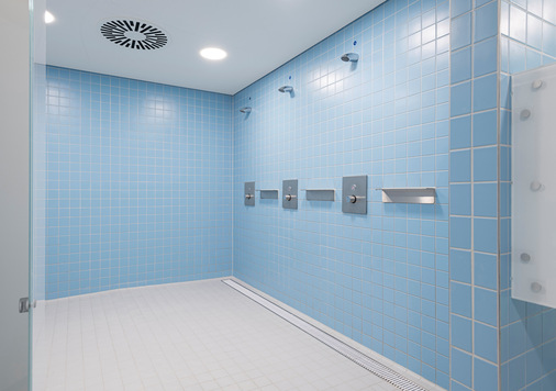 Die individuell gefertigten Entwässerungsrinnen einschließlich der Bodenabläufe und Rollroste in den Duschbereich des Sportbad Neckarpark stammen von ACO Haustechnik.