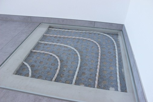 Ein weiterer Schaukasten veranschaulicht das Klettvlies, das direkt auf dem Bestandsestrich verlegt wurde. Die Besonderheit dabei: Die geringe Rohrüberdeckung des Fließestrichs von nur wenigen Millimetern.