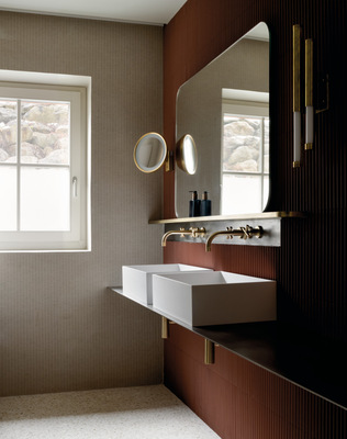 Auch in den weiteren Bädern unterstreicht Tara in Messing gebürstet (23kt Gold) die subtile Eleganz der Architektur – hier in Verbindung mit schlichten weißen Aufsatzbecken.